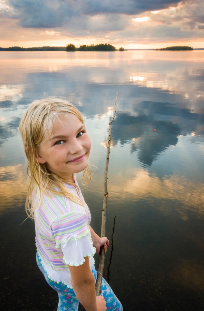 Tyttö onkimassa järvellä.